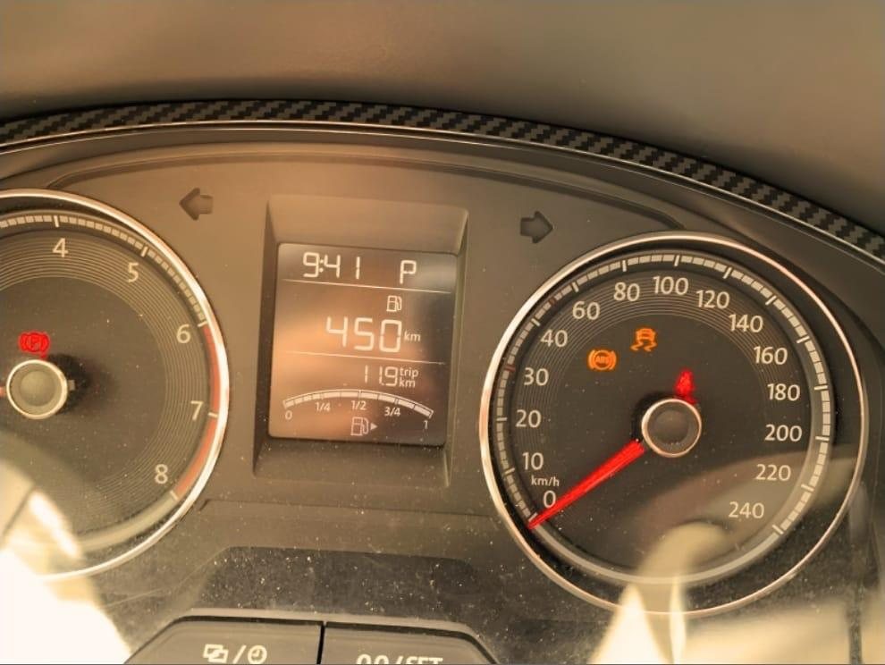 A car instrument cluster with warning lights lit at 450 kilometres on the odometer